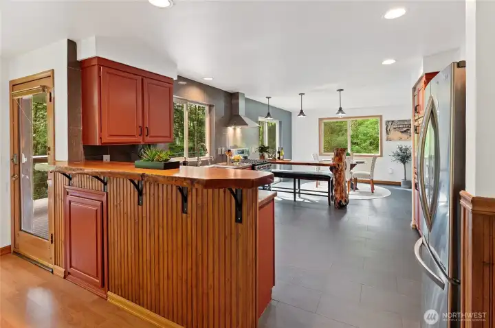 The kitchen features a unique live-edge bar, anchored by a tree. Watch nature as you do the dishes.