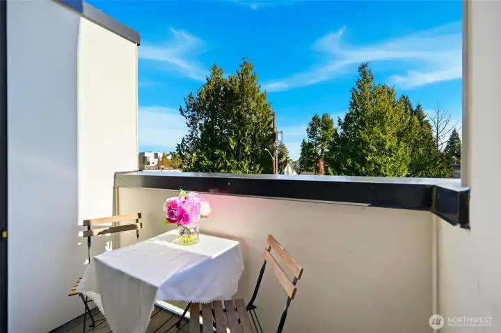 Private balcony offering outdoor space with room for seating and treetop views.
