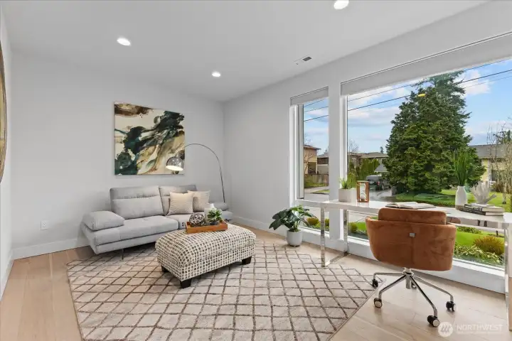 Main-floor office with oversized windows, soft natural light, and a serene setting for focused days at home.