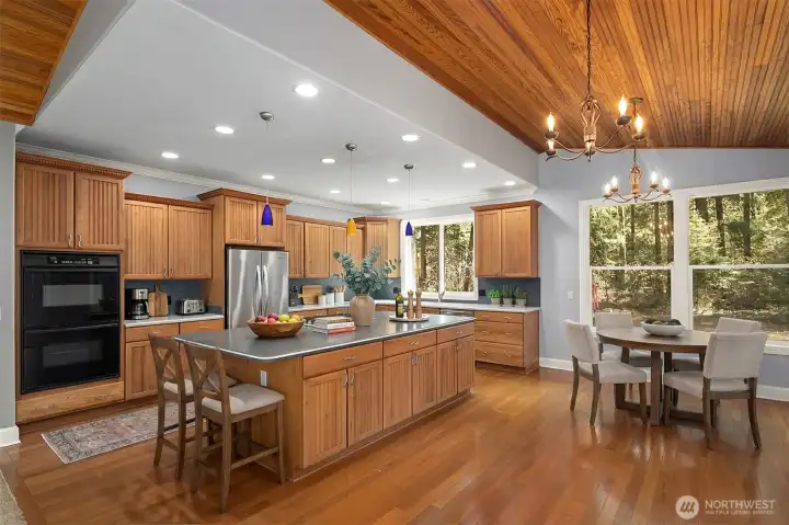 Virtually staged open concept kitchen, dining area with sparking Brazilian hardwoods and vaulted ceilings