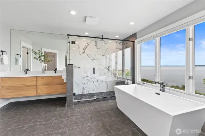 Primary En-suite bath features extra-deep soaking tub, heated floors, and marble-walled shower.