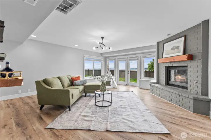 Downstairs, the 3rd family living room, anchored by gas fireplace, built-in bench-seating and French doors.