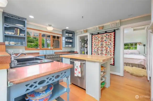 The kitchen boasts attractive open shelving, plenty of storage, and a custom built island.