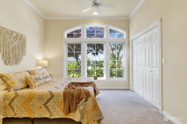 Featuring a ceiling fan and a transom window to invite natural light, this room is the perfect space for guests.