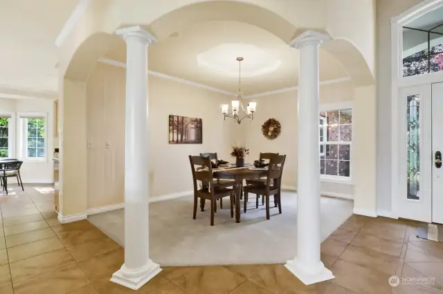 The elegant dining room is framed by columns, with coffered ceilings enhancing the sense of luxury.