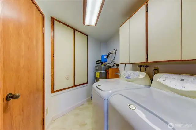 Brightly lit utility room with full-size washer/dryer and utility sink for pets or messy projects.