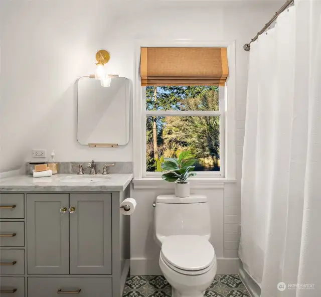 Ensuite bathroom in the carriage house with cement tile flooring, full bath and single vanity - all remodeled in 2018.