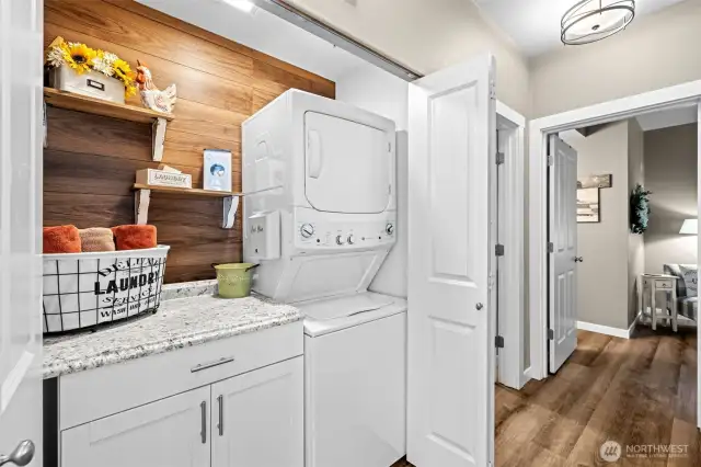 Tucked neatly behind double doors, this updated laundry zone offers bonus counter space, extra storage, and a stylish backsplash that makes chores feel less like... chores.