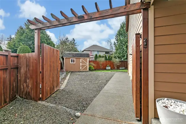 The side yard is complete with large double gates wide enough to drive through. The large garden shed can be seen in the background.