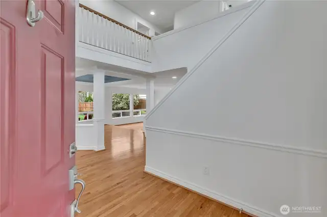 Gleaming wood floors greet you at the front entry with a soaring ceiling above.
