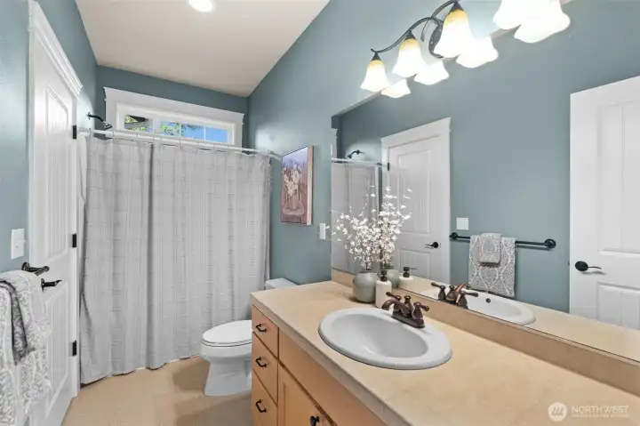 Spacious bathroom accessible from bedroom and hallway.