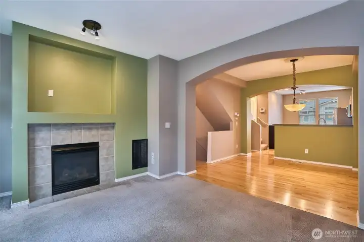 Living room with gas fireplace open to dining area and kitchen.