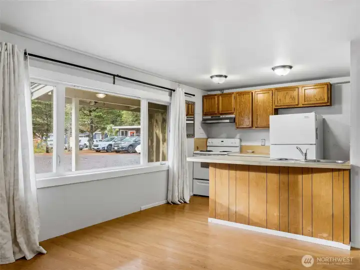 Kitchen, lliving area combo with a bar space for eating.