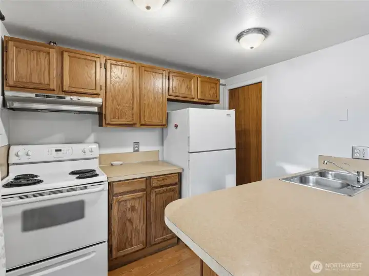 Kitchen, lliving area combo with a bar space for eating.