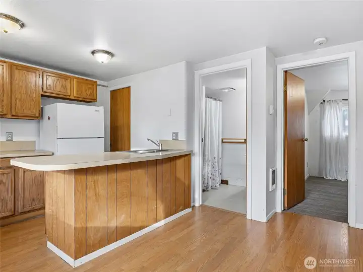 Kitchen, lliving area combo with a bar space for eating.