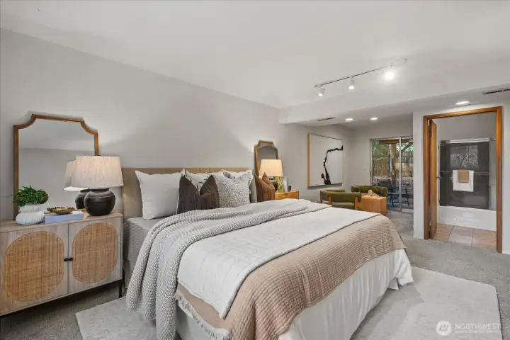 Downstairs features a generous third bedroom retreat with an en suite bath and comfortable sitting area. It opens directly to the outdoor patio and backyard beyond creating a seamless indoor outdoor space, ideal for relaxation.