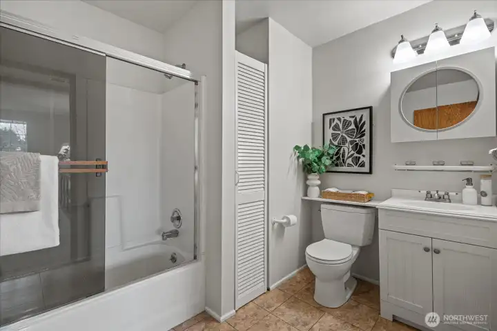 Large downstairs bathroom with storage closet and new lighting.