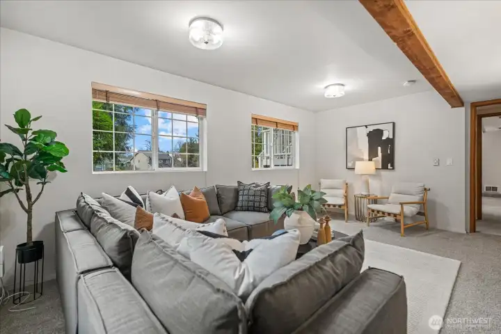 This fourth bedroom/family room features a lovely ceiling beam accent, new, updated lighting, and two large windows that fill the space with abundant natural light for a bright airy feel.