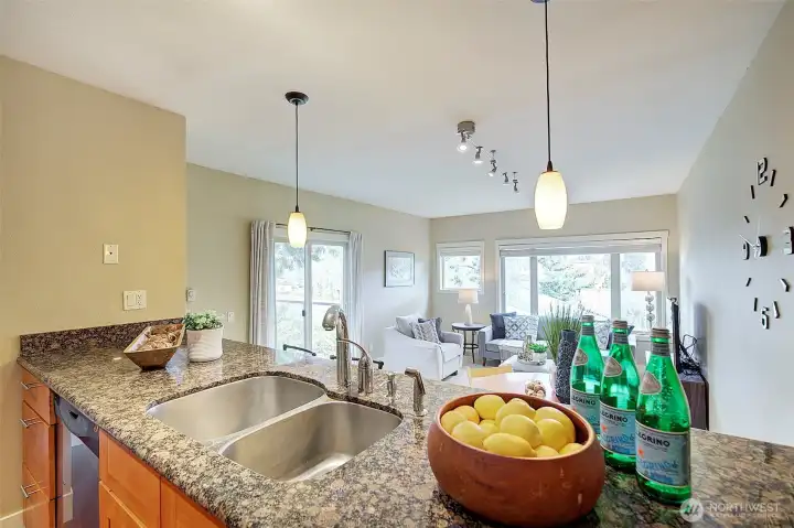 A view of the living/dining area from the kitchen with granite countertop.