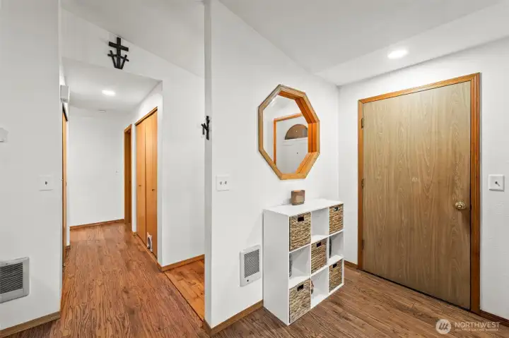 Back at the entry, the door on the right leads to the garage. Down the hallway on the left, there’s storage, a large laundry, all 3 bedrooms, and both bathrooms.