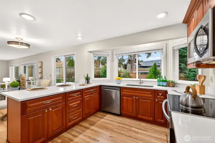 The kitchen has been thoughtfully improved with new quartz countertops and sink, abundant cherry cabinetry, and generous prep space that supports both daily routines and entertaining. New LG stainless range and dishwasher add everyday convenience while large windows bring in natural light
