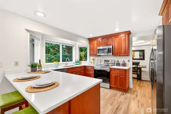 Cherry cabinetry, expansive counters, and multiple windows give the kitchen a warm, welcoming feel with excellent workspace and storage. The thoughtful updates here blend style and utility in a way that supports comfortable everyday living.