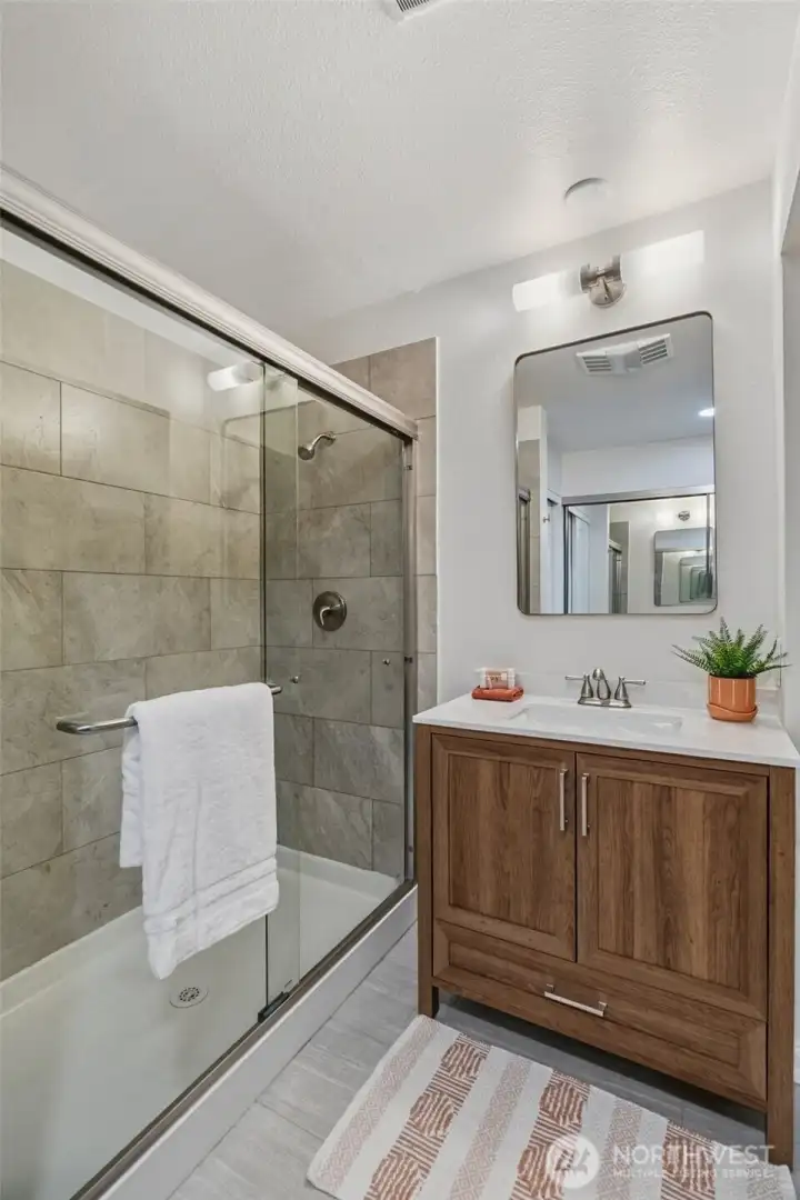 Primary 3/4 en-suite bathroom with new vanity, mirror and lighting