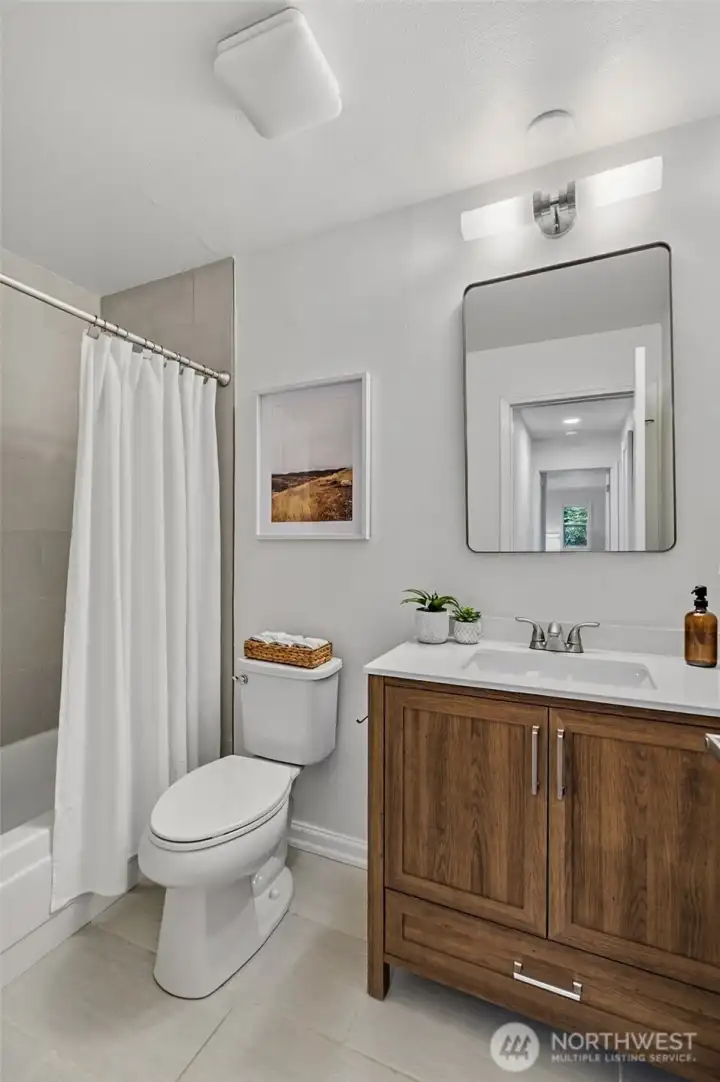 Updated Main Bathroom complete with tiled shower new vanity, mirror and lighting