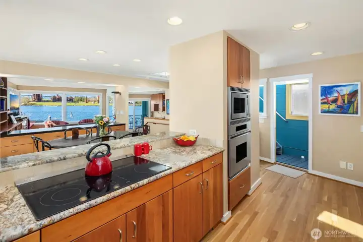 The long serving bar connects the kitchen to the dining and living rooms, with the lake and a passing fleet of boats filling the windows beyond.