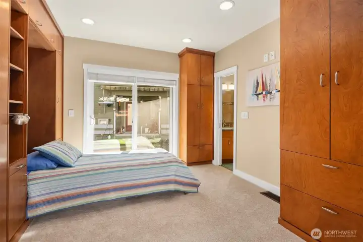 The guest suite with its wall of cherry cabinetry concealing custom twin XL Murphy beds — a true second bedroom that doubles as a study, studio, or workout room when guests aren't in town.