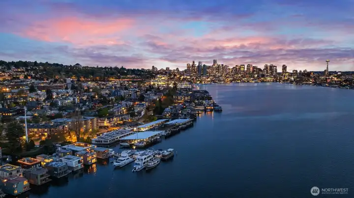 Golden hour giving way to blue: the Seattle skyline glows across Lake Union, with the home's rooftop deck in the glitter below.