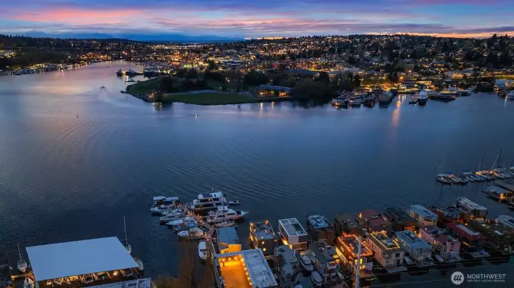 A twilight view west across Lake Union, with Gas Works Park and the distant ridge of the Olympic Mountains catching the last color of the day.