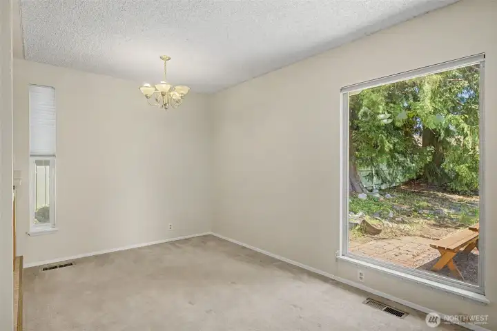 informal eating area looking out onto the backyard. Tons of light through the massive windows.