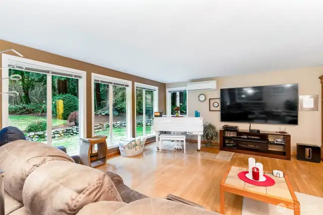 Living room on main floor has floor to ceiling windows looking out to the back yard.