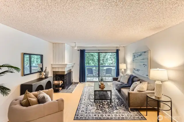 Large and inviting living space with fireplace and sliders to balcony