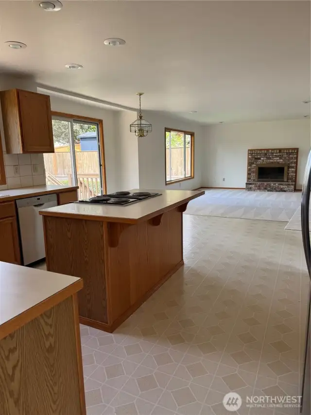 Kitchen open to family room with cozy fireplace.