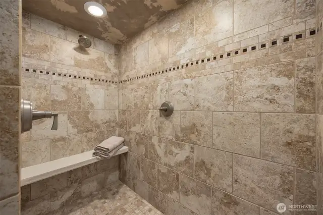 Freshly re-grouted tile in this expansive dual shower head walk in shower!