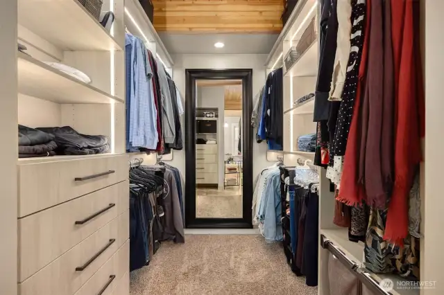 Very large walk in closet with thoughtful lighting lining every storage space.