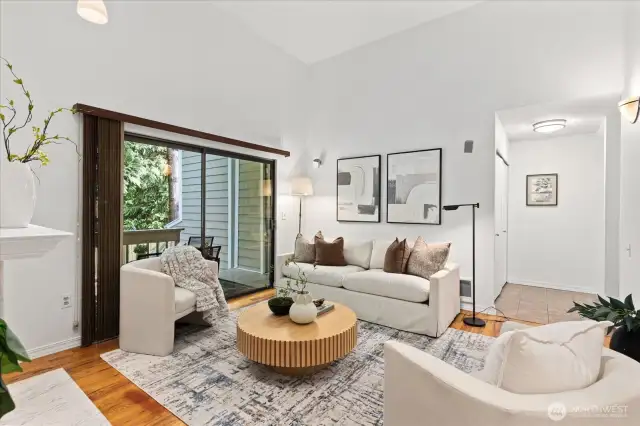 Bright living room with vaulted ceilings, skylights, and cozy fireplace.