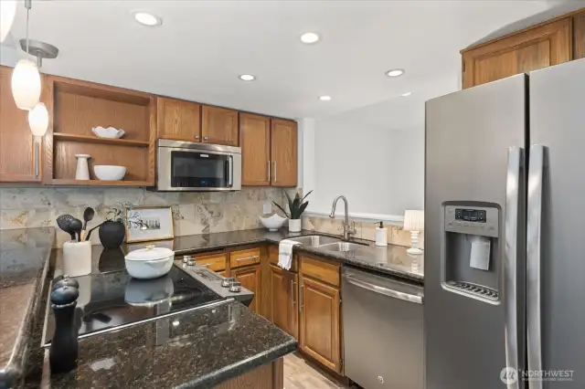 Updated kitchen with stainless appliances and stone counters.