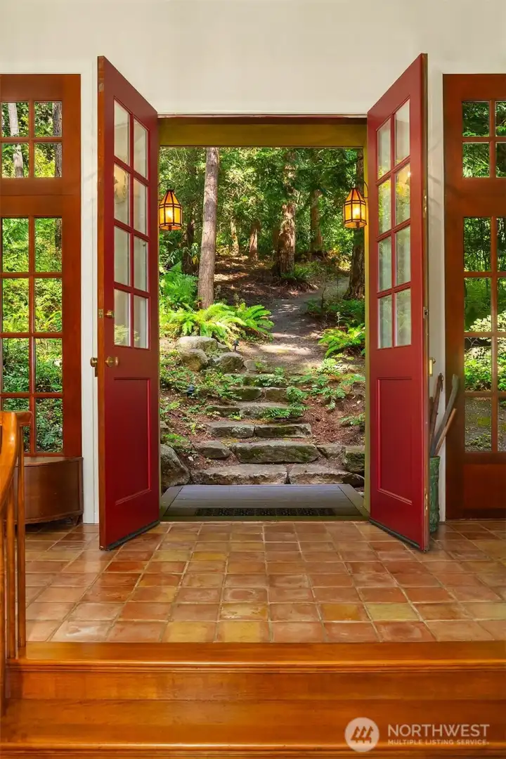 Double door entry with mission style lighting and clay tile flooring.