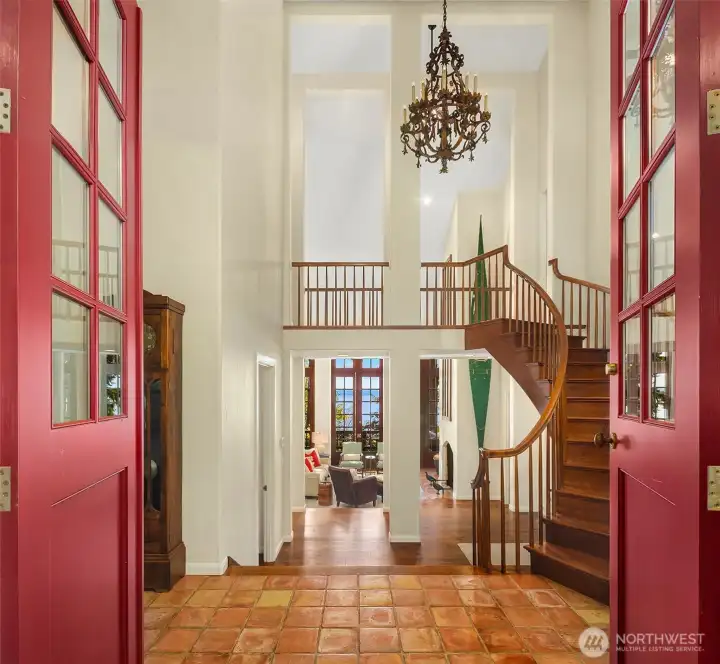Two story height entry with chandelier and direct access to second level wood staircase.
