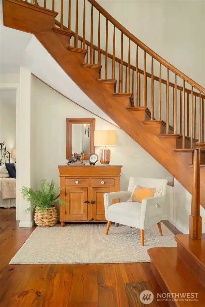 Welcoming entry with seating area and curved staircase to second level.
