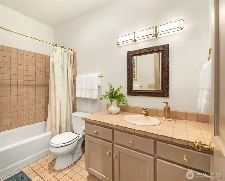 Ensuite guest bathroom with tub and shower combination.