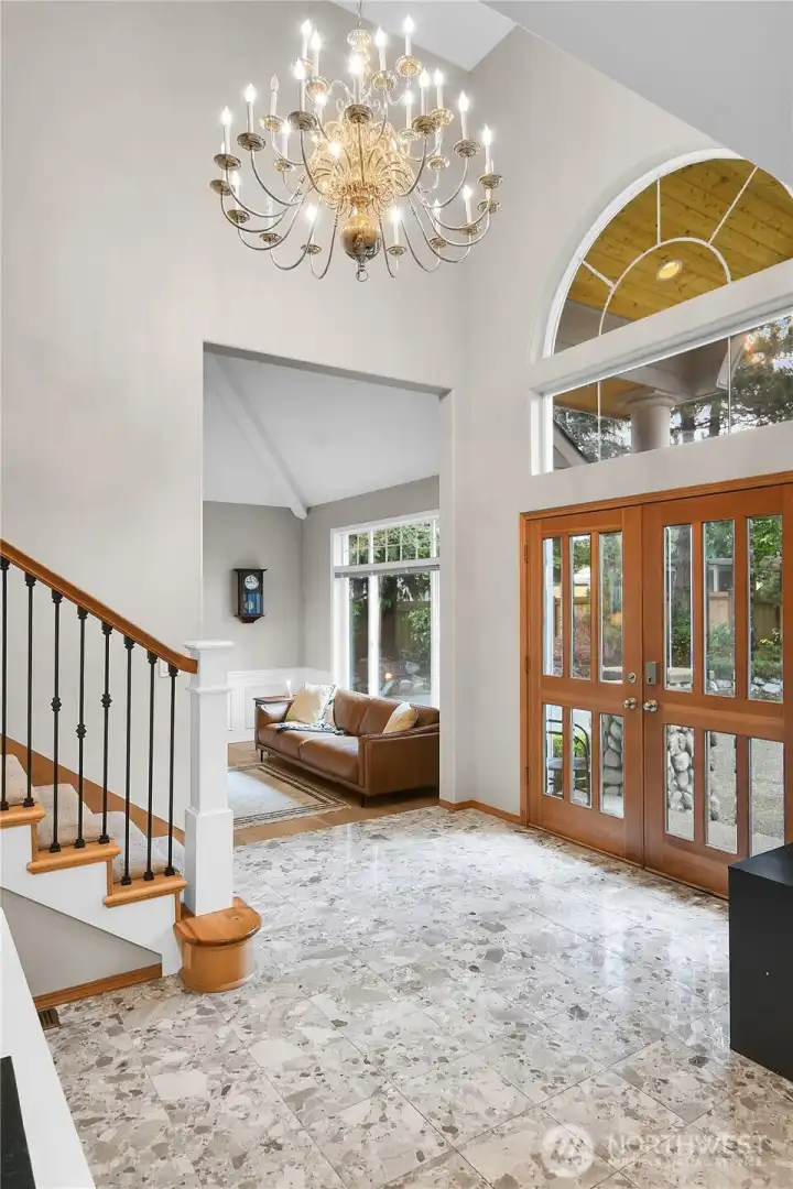 Dramatic foyer with marble floor, vaulted ceilings, and grand staircase