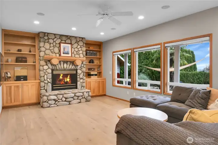 Family room with custom gas fireplace, wood built ins, and LVP flooring