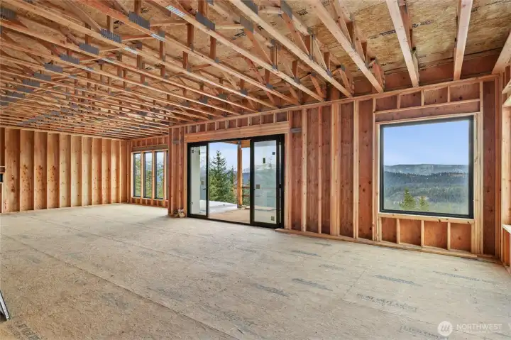 Living room with large picture window and large sliders for deck access.  Dining room at the far end with windows to maximize the views.