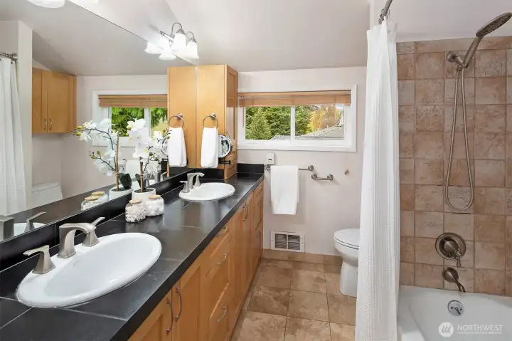 The top floor bathroom has tons of cabinetry and a laundry chute!