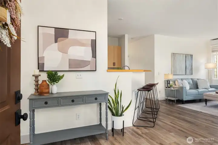 A stylish entryway welcomes you into the home with warm hardwood-style flooring and an open sightline straight through to the bright, airy living area, setting the stage for the thoughtful and connected layout within.
