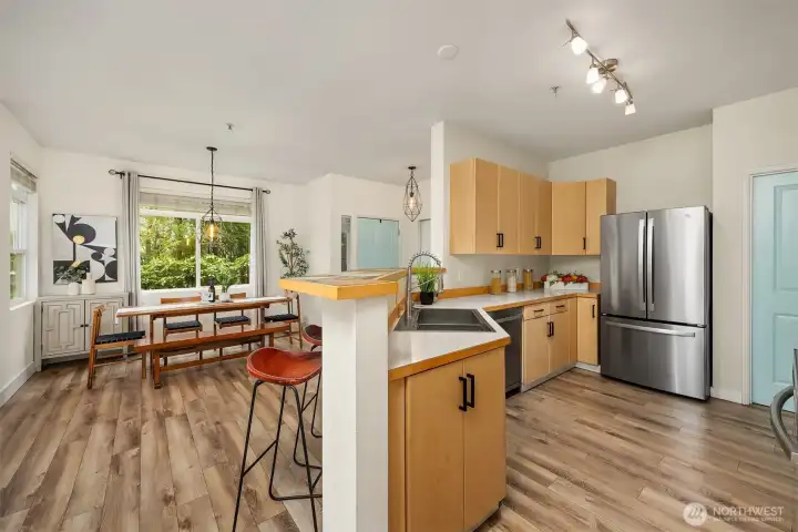 The well-appointed kitchen offers warm wood cabinetry, stainless steel appliances, and an open connection to the dining area, a functional and inviting space designed for effortless everyday living and entertaining.